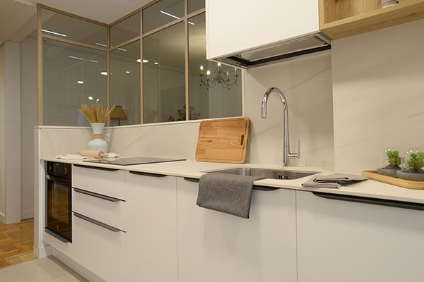 Cocina moderna en blanco con encimera clara y muebles a medida