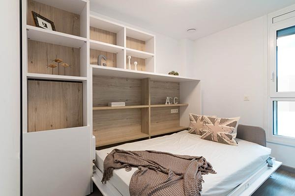 Cama abatible con estantería integrada en dormitorio juvenil
