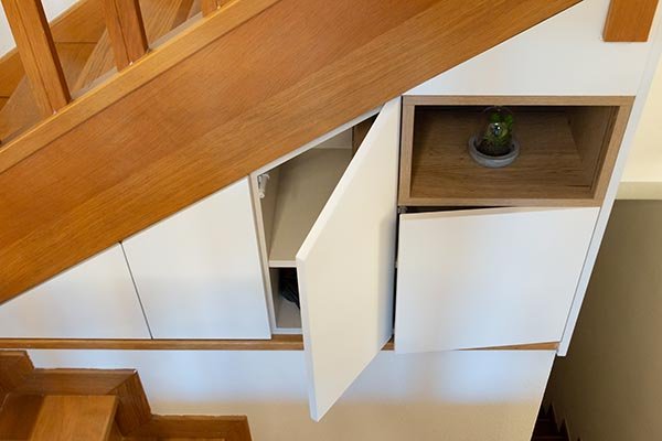 Muebles a medida en hueco de escalera con puertas blancas
