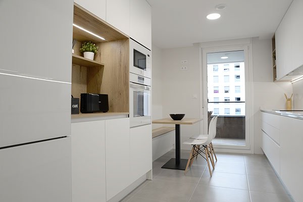 Cocina con muebles a medida en blanco y zona de office integrada