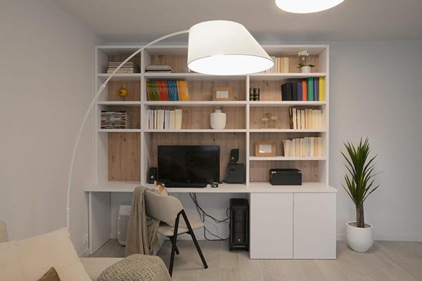Librería blanca a medida con escritorio integrado en salón