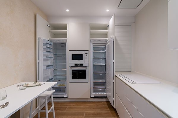 Cocina con frigoríficos panelados y horno integrado en columna