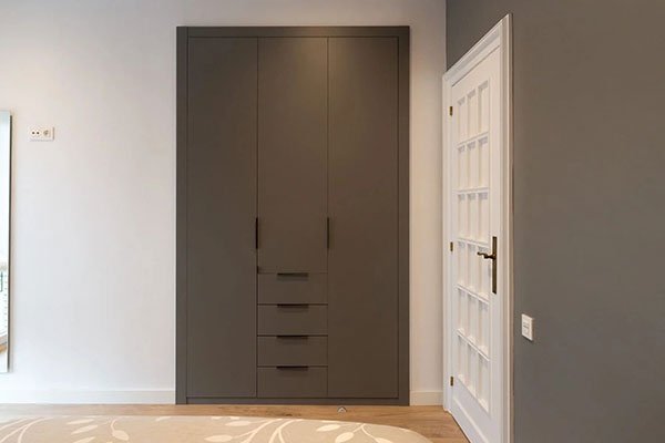 Armario empotrado de puertas lisas en color gris oscuro con cajones integrados