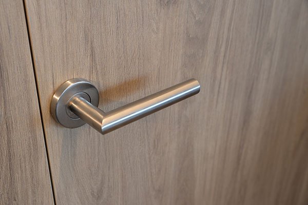 Manilla de acero inoxidable en puerta de madera