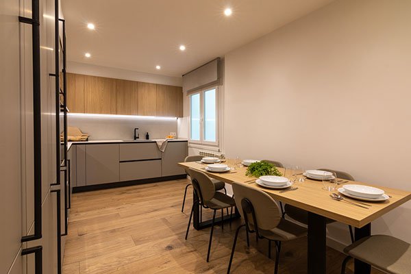 Cocina moderna con suelo de madera y comedor integrado