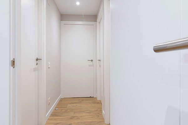 Pasillo con varias puertas interiores lacadas en blanco